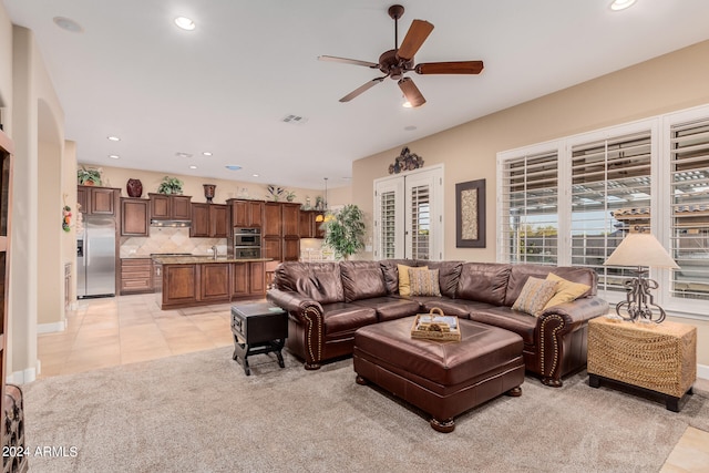 living room featuring ceiling fan, light tile patterned flooring, and sink