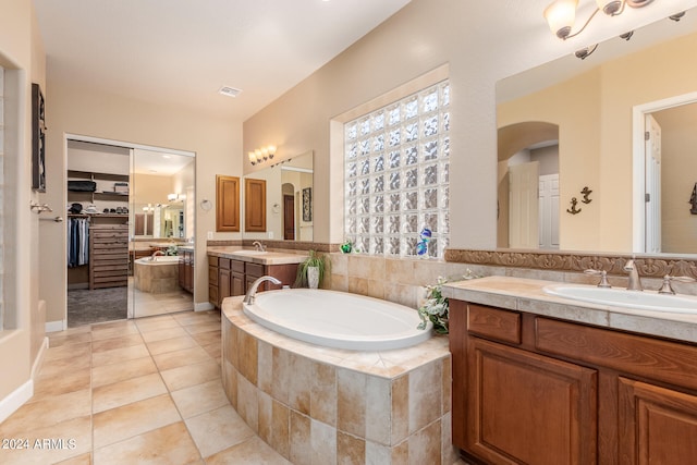 bathroom featuring tiled bath, vanity, and tile patterned floors