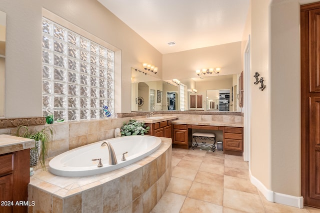 bathroom with tiled tub, vanity, and tile patterned flooring