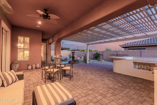 patio terrace at dusk with a pergola, area for grilling, and ceiling fan