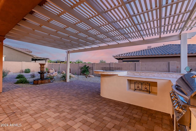 patio terrace at dusk with a pergola and grilling area