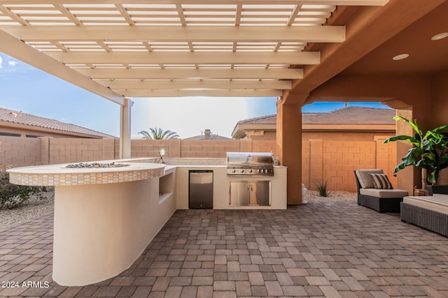 view of patio / terrace with a pergola, an outdoor kitchen, and grilling area