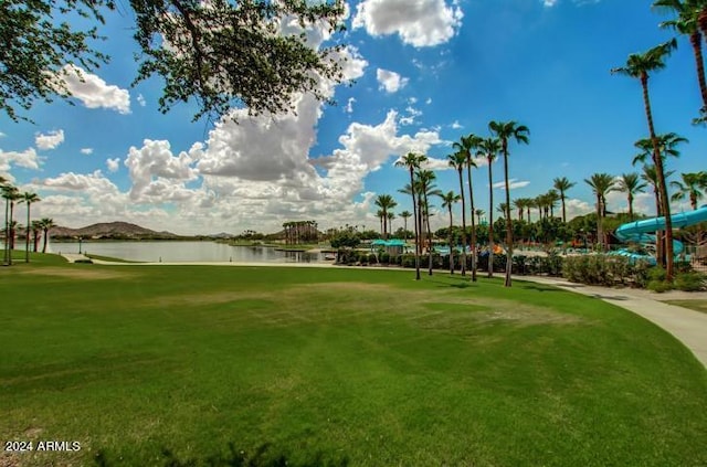 view of property's community featuring a water and mountain view and a lawn