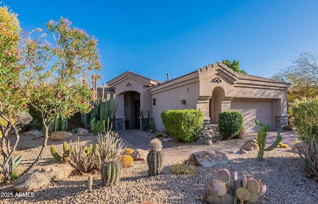 mediterranean / spanish home with an attached garage and stucco siding