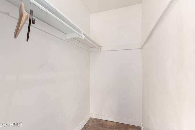 spacious closet with dark tile patterned floors