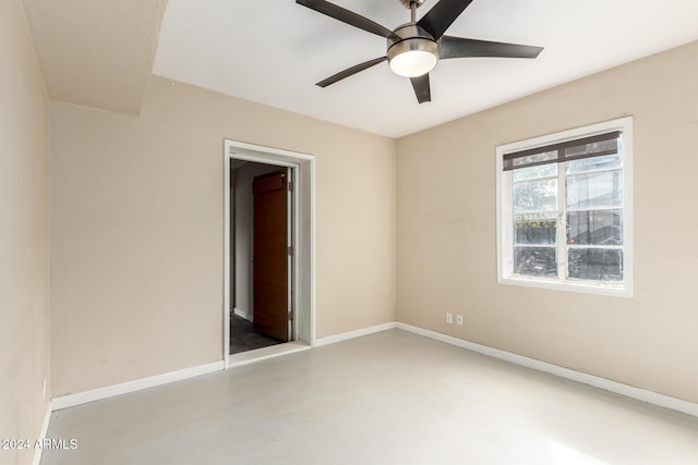 unfurnished room with ceiling fan and concrete floors