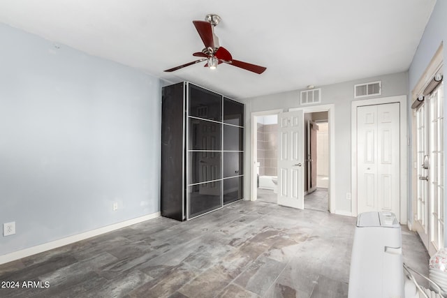 unfurnished bedroom with ensuite bathroom, a closet, and ceiling fan