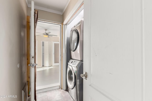 washroom with ceiling fan, light tile patterned flooring, stacked washing maching and dryer, and ornamental molding