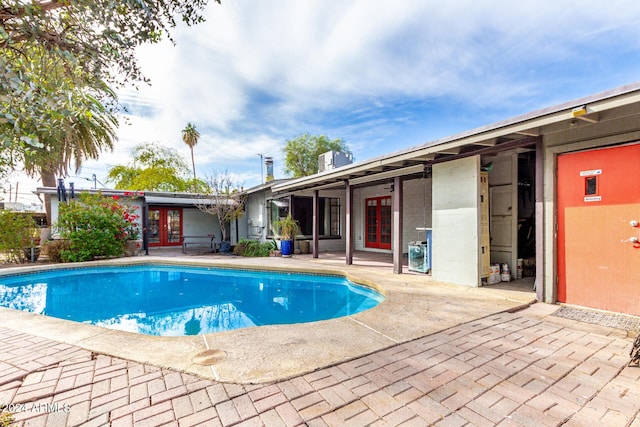 view of swimming pool featuring a patio and french doors