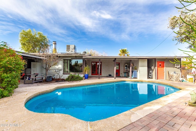 view of pool with central AC unit and a patio