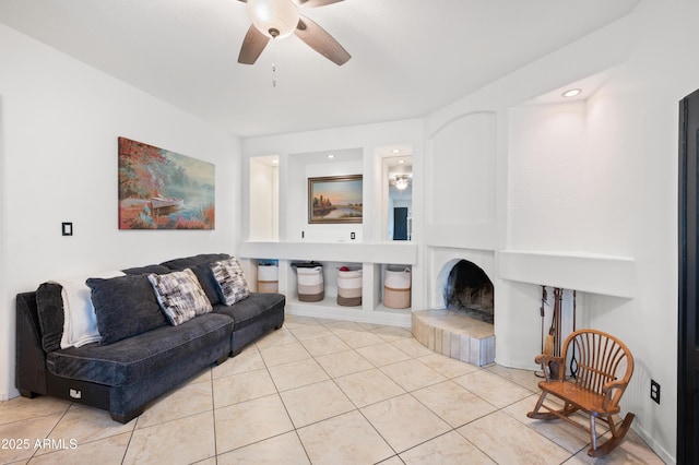 tiled living room featuring a tiled fireplace and ceiling fan