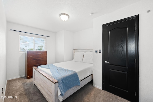 bedroom with dark carpet and a textured ceiling