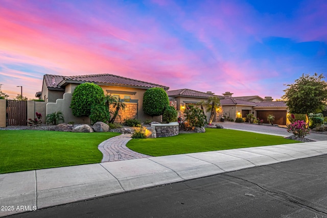 mediterranean / spanish-style home featuring a yard and a garage