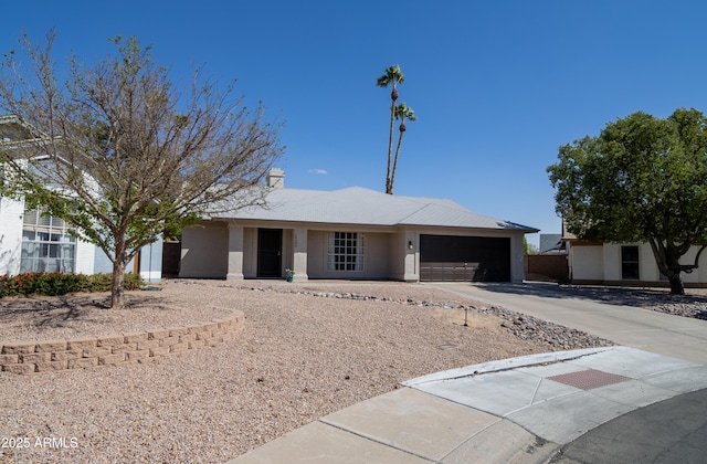 ranch-style home featuring an attached garage, concrete driveway, and stucco siding