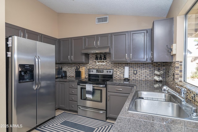 kitchen with visible vents, lofted ceiling, stainless steel appliances, under cabinet range hood, and a sink