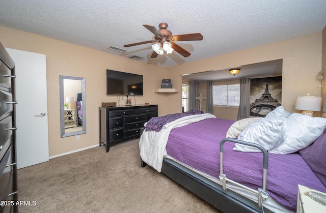 carpeted bedroom featuring a ceiling fan, visible vents, and a textured ceiling