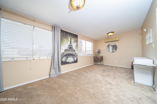 carpeted spare room with an AC wall unit and baseboards