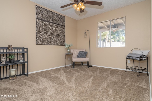 living area featuring carpet flooring, ceiling fan, a textured ceiling, and baseboards