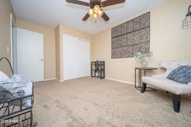 living area with carpet, ceiling fan, a textured ceiling, and baseboards