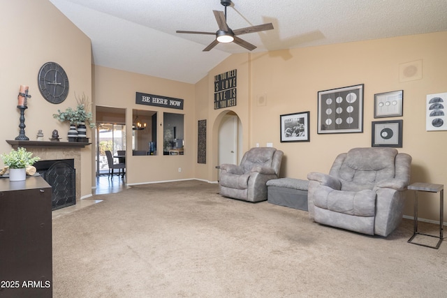 sitting room with carpet floors, arched walkways, a fireplace with flush hearth, ceiling fan, and high vaulted ceiling