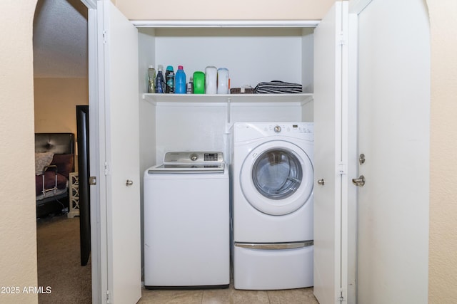 laundry room with laundry area, independent washer and dryer, and light tile patterned floors