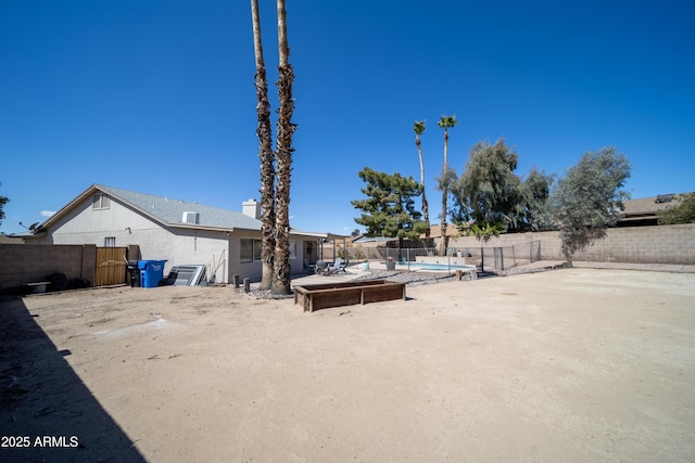 view of yard featuring a fenced backyard, a community pool, and a patio