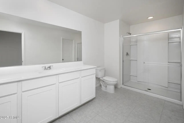 bathroom featuring toilet, a stall shower, vanity, and tile patterned floors