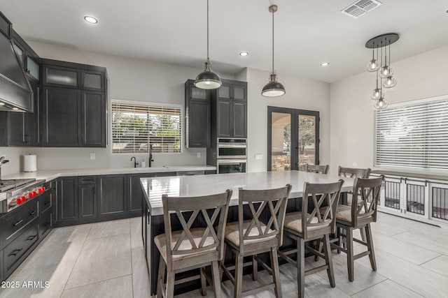 kitchen featuring a breakfast bar, a sink, visible vents, light countertops, and french doors