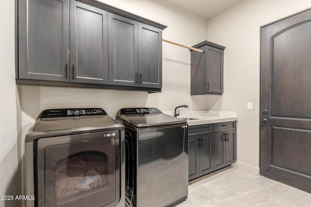 laundry room with cabinet space, baseboards, washing machine and clothes dryer, a sink, and light tile patterned flooring