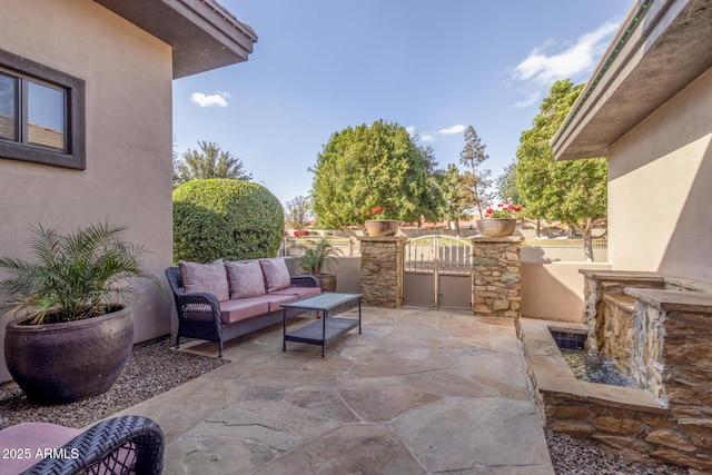 view of patio with a gate, outdoor lounge area, and fence