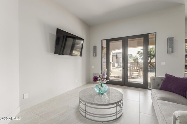 living area featuring french doors, tile patterned floors, and baseboards