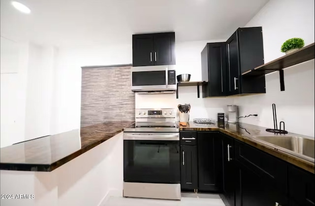 kitchen with kitchen peninsula, stainless steel appliances, and sink