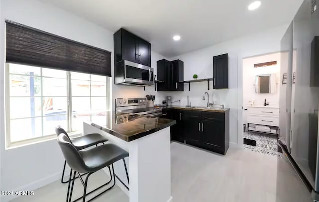 kitchen featuring a breakfast bar, appliances with stainless steel finishes, and sink