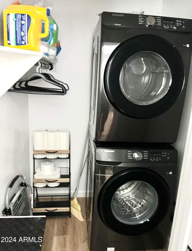 washroom featuring wood-type flooring and stacked washer and dryer