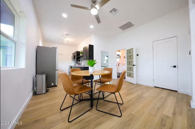 dining space with ceiling fan, light hardwood / wood-style flooring, and sink