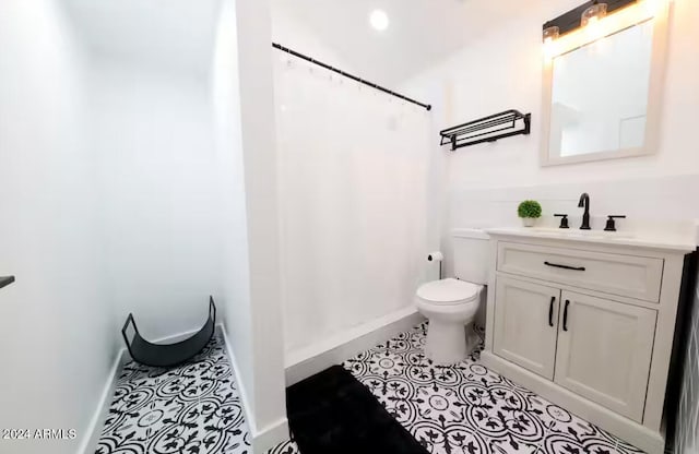 bathroom featuring tile patterned floors, vanity, and toilet