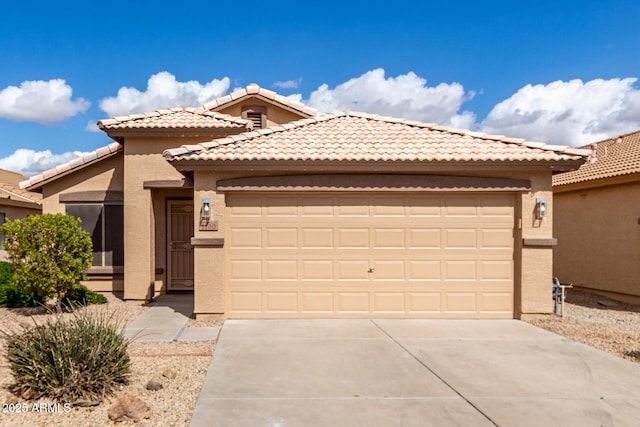 view of front of home with a garage, concrete driveway, a tile roof, and stucco siding