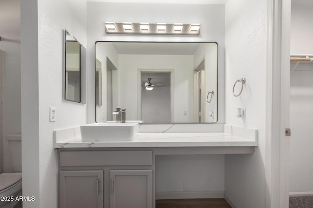 bathroom featuring vanity, toilet, and a ceiling fan