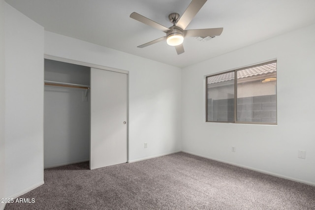 unfurnished bedroom featuring carpet floors, visible vents, a ceiling fan, and a closet