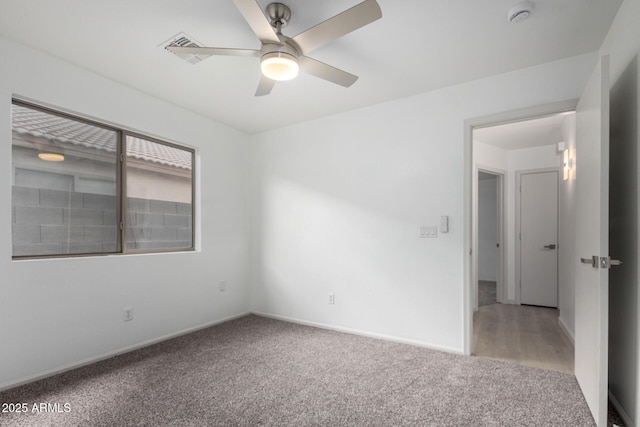 empty room featuring carpet, a ceiling fan, and baseboards