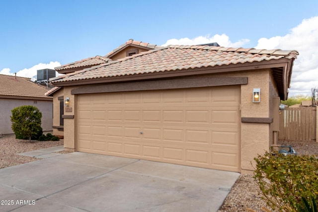 view of front of property featuring driveway, a tiled roof, central AC, and stucco siding