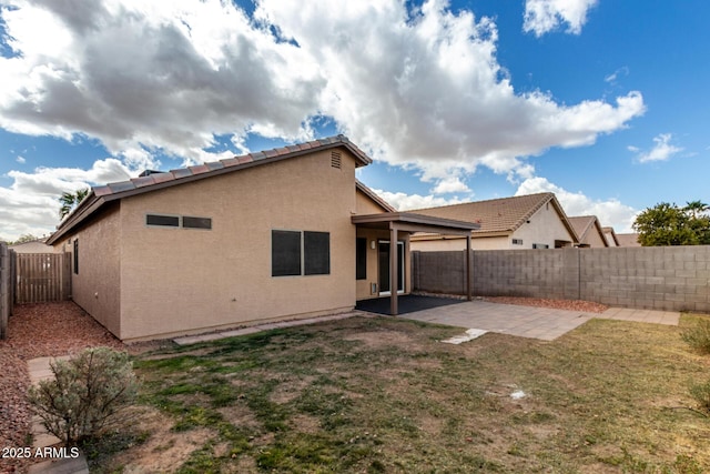 back of property with a yard, a patio area, a fenced backyard, and stucco siding