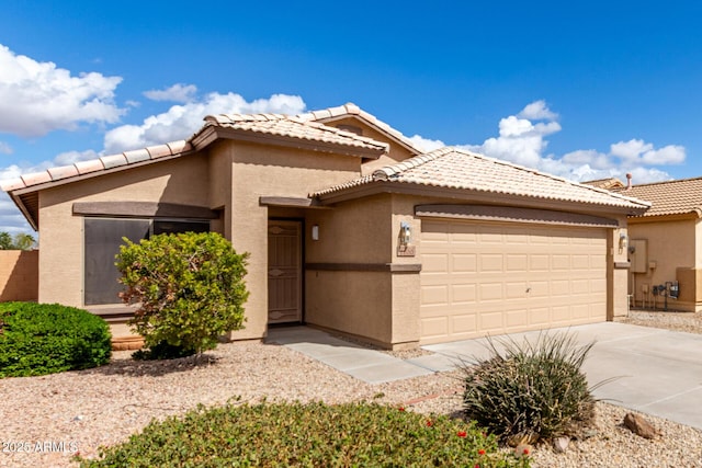 view of front facade featuring a garage, concrete driveway, a tile roof, and stucco siding