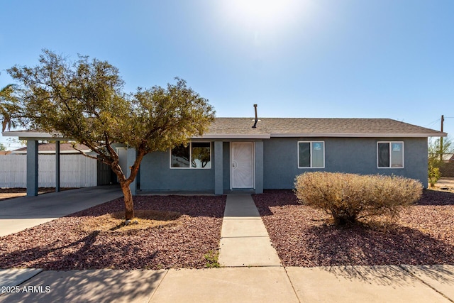 single story home with driveway, a shingled roof, fence, and stucco siding