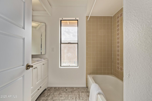 bathroom featuring a healthy amount of sunlight, vanity, and tiled shower / bath combo