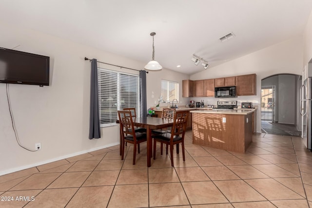 dining room with lofted ceiling and light tile patterned floors