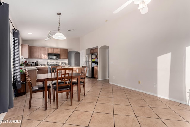 tiled dining room with high vaulted ceiling and ceiling fan