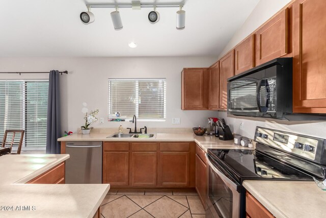 kitchen with light tile patterned floors, sink, appliances with stainless steel finishes, and track lighting