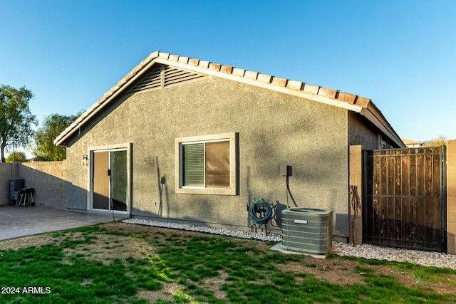 rear view of property with central AC and a patio area