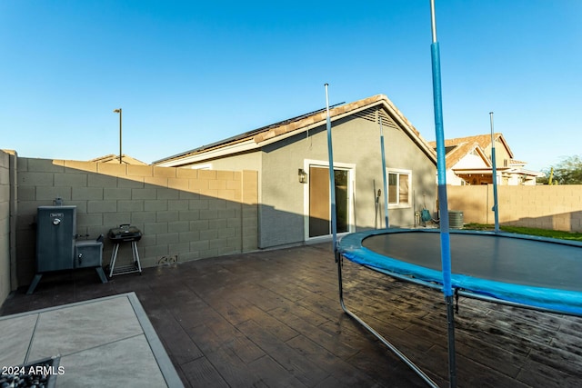 rear view of property with a trampoline